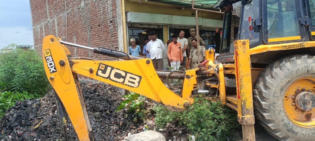 चिउटहां गांव में जेसीबी से जाम नालियों की सफाई करते कर्मचारी